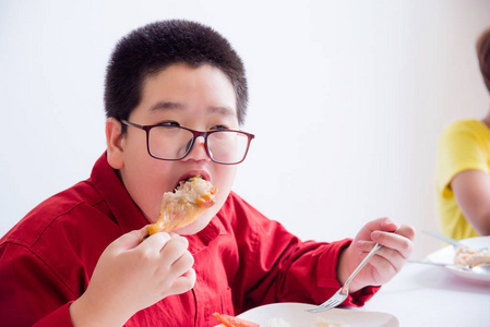 小亚洲男孩在学校食堂吃烤鸡