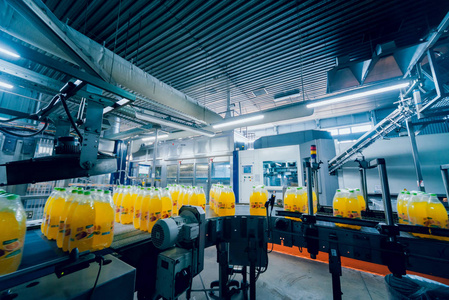 带果汁或水的瓶子的传送带.现代化设备照片