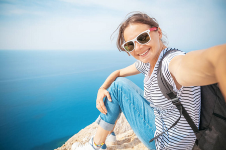 年轻美丽的女性旅游女孩做自拍在蓝色的海背景, 夏天旅行和假期概念, 幸福和自由