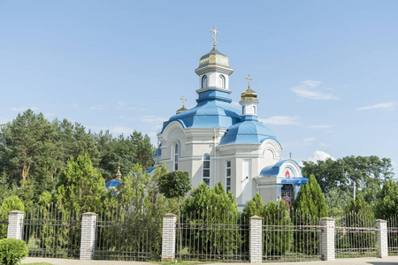 蓝色屋顶和金色圆顶的正统寺庙在风景如画的地方反对蓝色天空