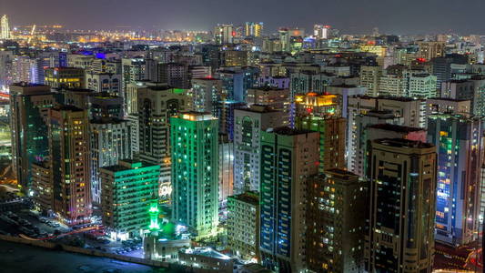 阿布扎比市中心的空中地平线, 从上面的所有夜间 timelapse 与照明摩天大楼和窗口闪烁的光