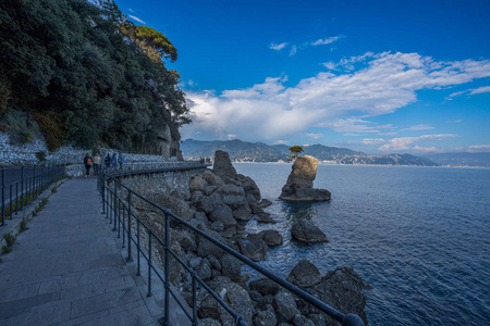 漫步在海岸附近的岩石与美丽的全景海洋海风景人步行