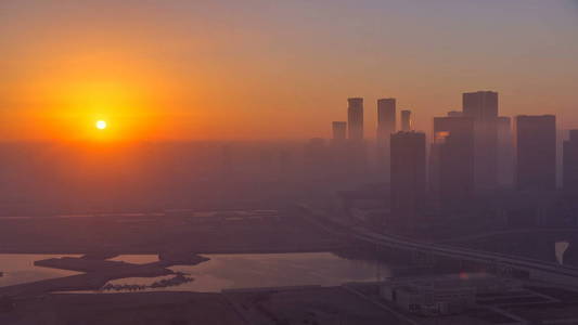 阿布扎比城市天际线上的摩天大楼在日出 timelapse 以上。空中鸟瞰在雾的早晨从屋顶