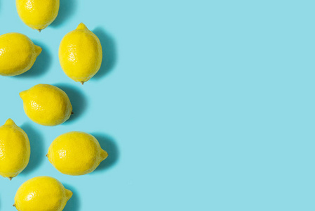 蓝色背景下的新鲜柠檬的顶部视图。水果最小的概念。复制空间