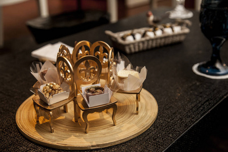 典雅的聚会糖果, 装饰着金色的小椅子。党的装饰理念
