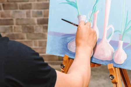 在画布上画的年轻女子艺术家与调色板和水彩颜料在家里