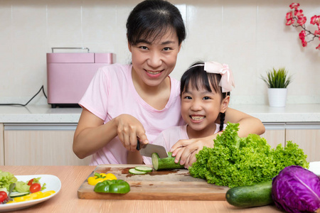 亚洲华人妈妈和女儿在家厨房做沙拉