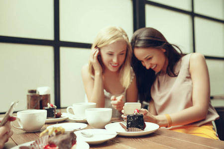 两个女孩的朋友一起在咖啡馆喝咖啡, 吃早饭和甜点。