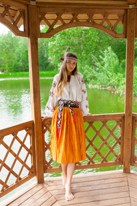 美丽细长的乌克兰人在有风的天气刺绣在夏天阳光明媚的一天在湖上休息