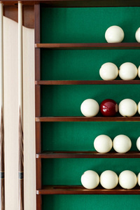 白色台球球和球杆在架子上的俄罗斯台球。绿布。木制提示