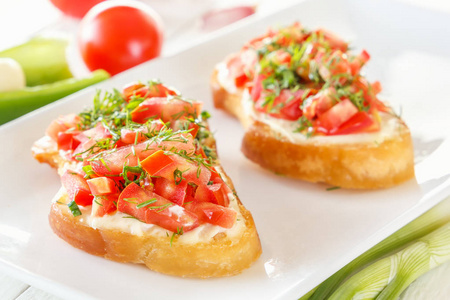 Bruschetta 用新鲜的西红柿和奶酪在白色木板旁边的新鲜蔬菜。特写