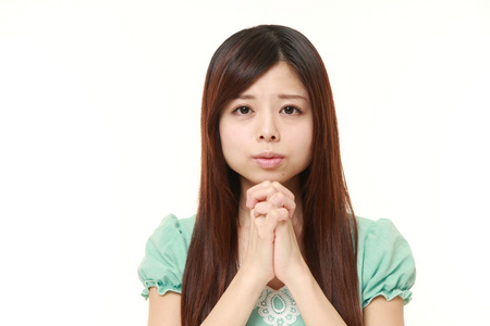 日本年轻女性在祷告中折叠她的手