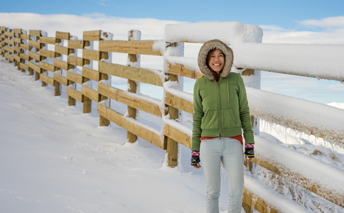 幸福的女人，站在滑雪场附近的木栅栏