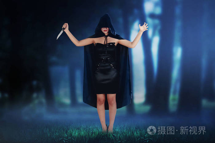 恐怖的亚洲巫婆妇女在黑暗的森林拿着刀子