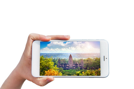 手中拿着智能手机与吴哥窟寺庙的形象，在柬埔寨暹粒