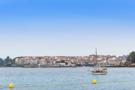 Portonovo 钓鱼和旅游村的海滨在前景的锚帆船