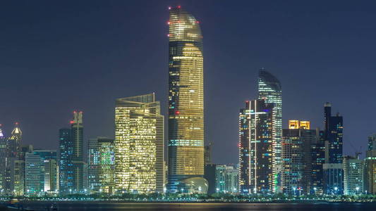 阿布扎比地平线和海滨的全景景观在晚上 timelapse, 阿拉伯联合酋长国。带照明摩天大楼的海滨大道景观