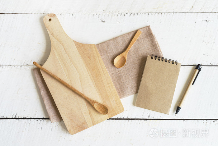 笔记本和木制器皿在厨房上白色木制背景