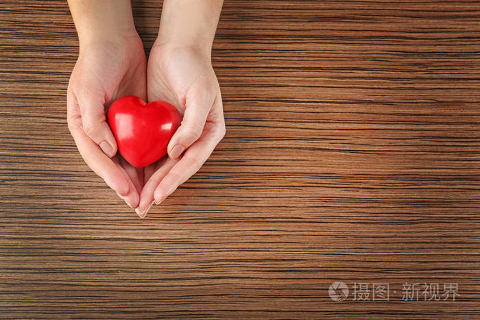 女性的双手握着红色的心