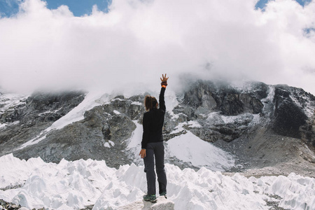 一个人旅行背影女性游客的背影在温暖的冬天穿上运动服举起她的手在
