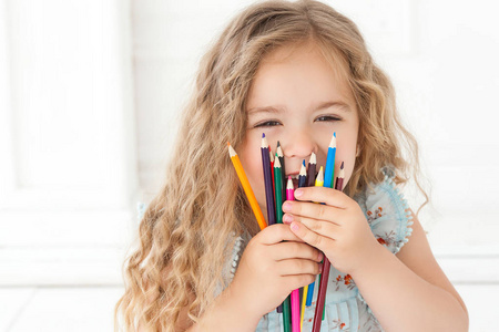 可爱的小女孩，用彩色铅笔在纸上画。漂亮