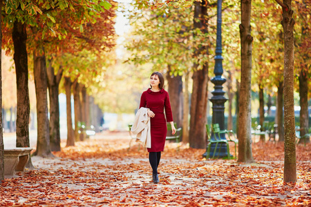 美丽的年轻女子在巴黎漫步在杜乐丽花园, 在一个明亮的秋季一天。法国秋季旅游与度假