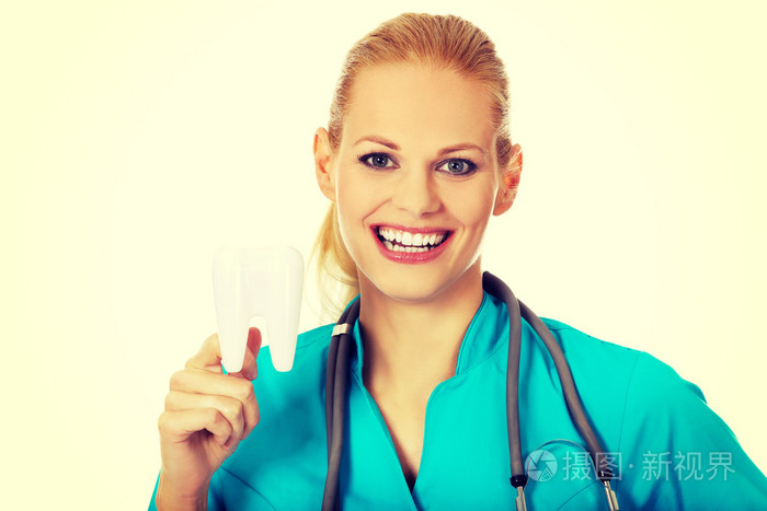 快乐牙医女人用听诊器持有牙齿模型