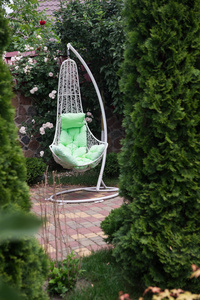 白色的椅子摇摇欲坠。在花园里休息的金属椅