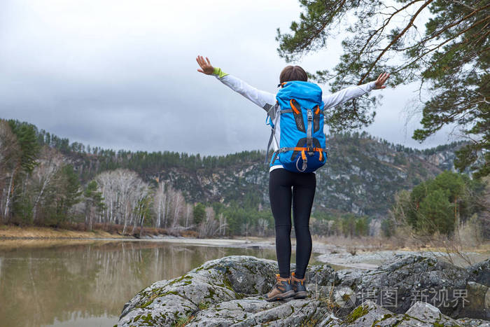 带着背包走路的女人.手放到一边.户外运动肖像