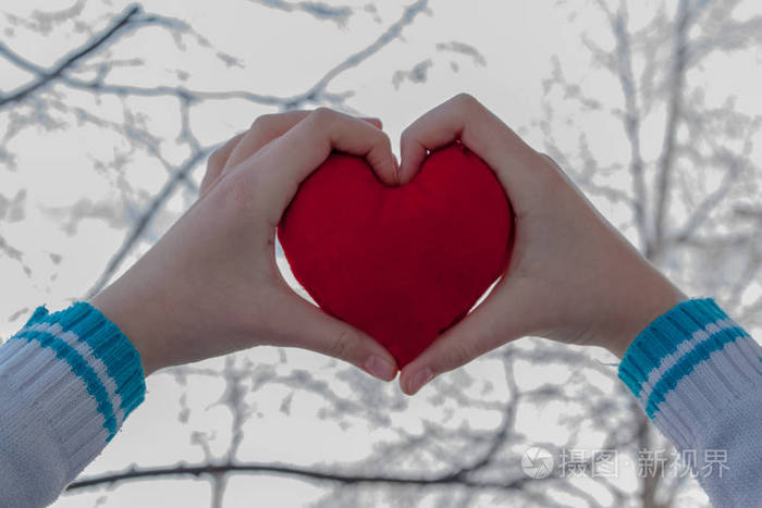 红色的心，在手中的妇女，作为情人节的礼物