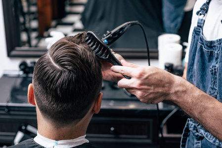 一个男人在美容院闲逛。理发和造型在理发店。男士护理胡子和头发