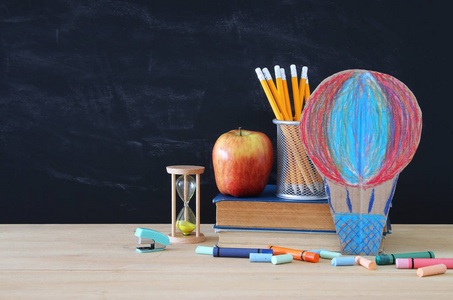 回到学校的概念。教室黑板前的热气球和铅笔