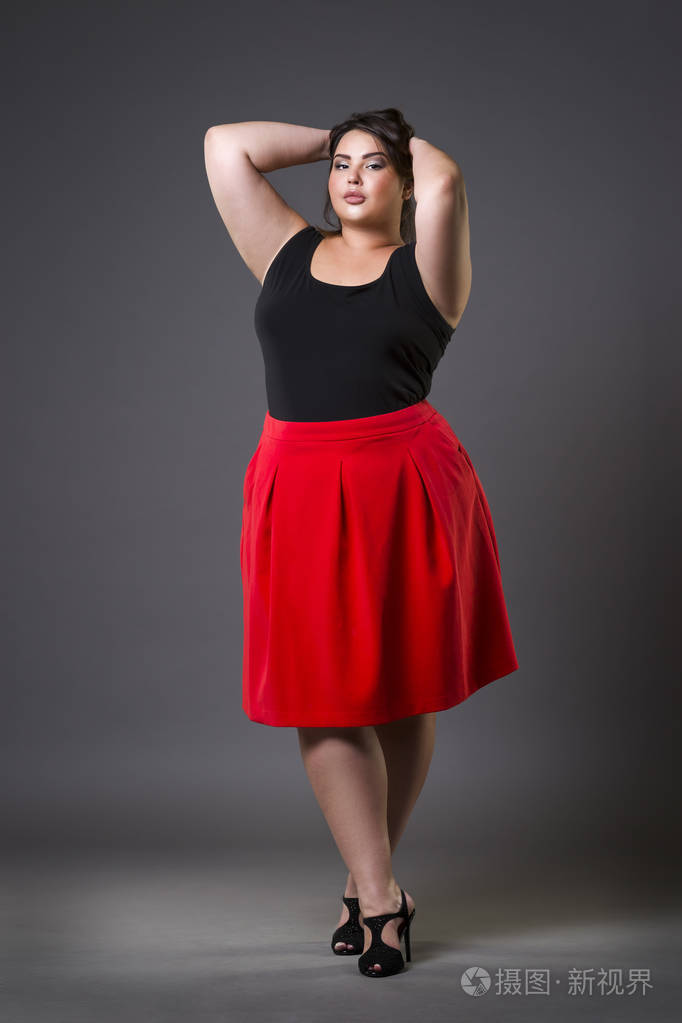 再加上大小时装模特穿红裙子,胖女人在灰色的背景下,超重女性的身体