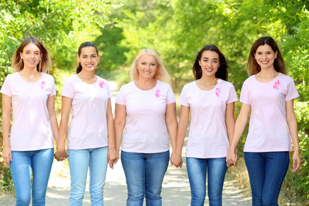 美丽的不同年龄的妇女与粉红色丝带户外。乳癌概念
