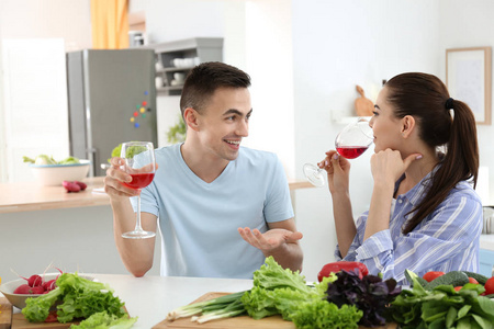 年轻夫妇在厨房一起做饭时喝葡萄酒