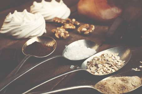 汤匙糖 咖啡 燕麦和酥皮 巧克力棉花糖 蜂蜜和真正棕色的木桌上的螺母