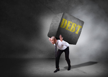 企业概念中债务的压力压力.商人走在他背上背着沉重的石头.