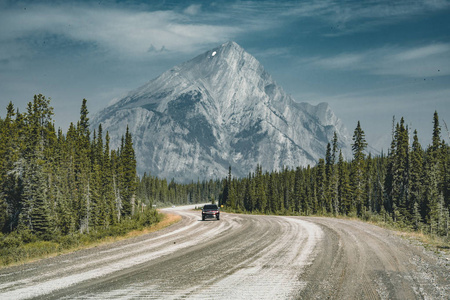 景观的街道公路与高山和树木与蓝天和云。加拿大班夫国家公园洛基山脉
