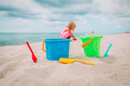 孩子们的玩具和沙滩上玩耍的小女孩