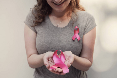 女性手捧粉红色丝带, 乳腺癌意识和10月粉红色概念