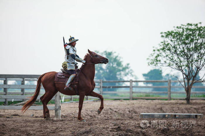 亚洲泰武士在传统的装甲西装骑马在农村农场的背景.复古战争服装概念