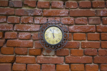 红砖砌成的墙上的老式站时钟