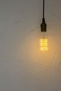 灯泡挂在白墙上