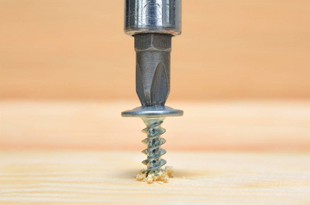 拧螺丝螺丝螺丝刀拧在木板.细木工和建设紧密.电力工具运行照片