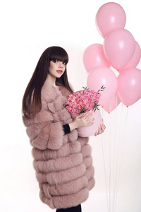 在粉红色的皮大衣，玫瑰花束花的年轻黑发女孩