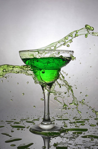 在绿色含酒精的鸡尾酒饮料玻璃飞溅