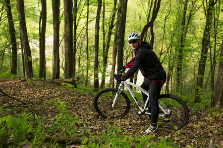 骑车人骑自行车在美丽的春天森林