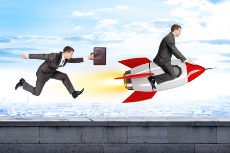 上升火箭运行商人后火箭飞行的人照片