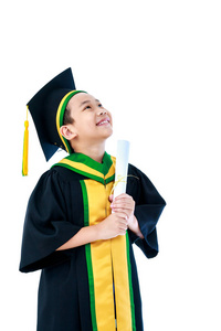 幼儿园毕业。亚洲儿童毕业礼服持有文凭证书, 并期待在工作室与复制空间。愉快的男孩微笑与完美的微笑。在白色背景上被隔离