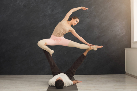 年轻夫妇在垫子上练习 acroyoga